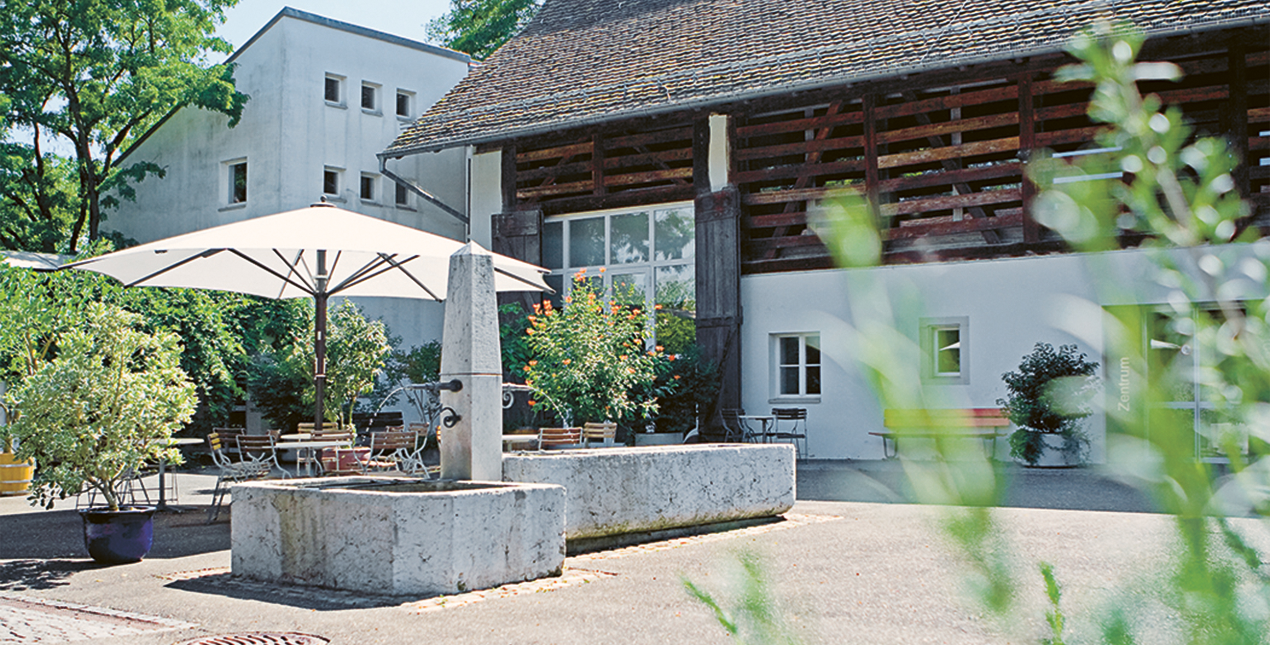 Der Innenhof vom Bildungszentrum mit Pflanzen und einem Brunnen.