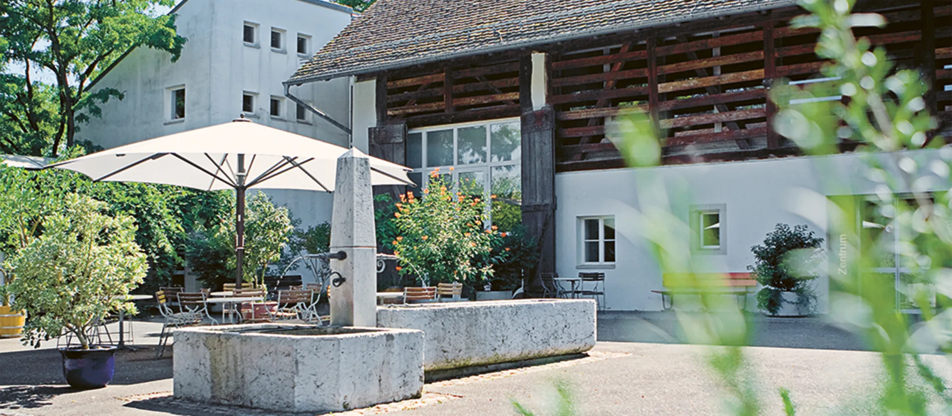 Der Innenhof vom Bildungszentrum mit Pflanzen und einem Brunnen.